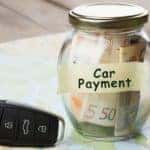 A close up is shown on a car payement jar and set or car keys.