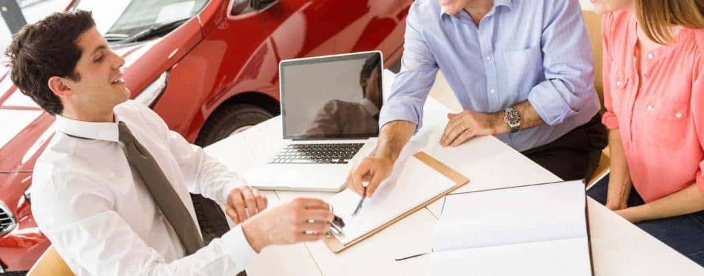Sales man explaining paperwork to couple