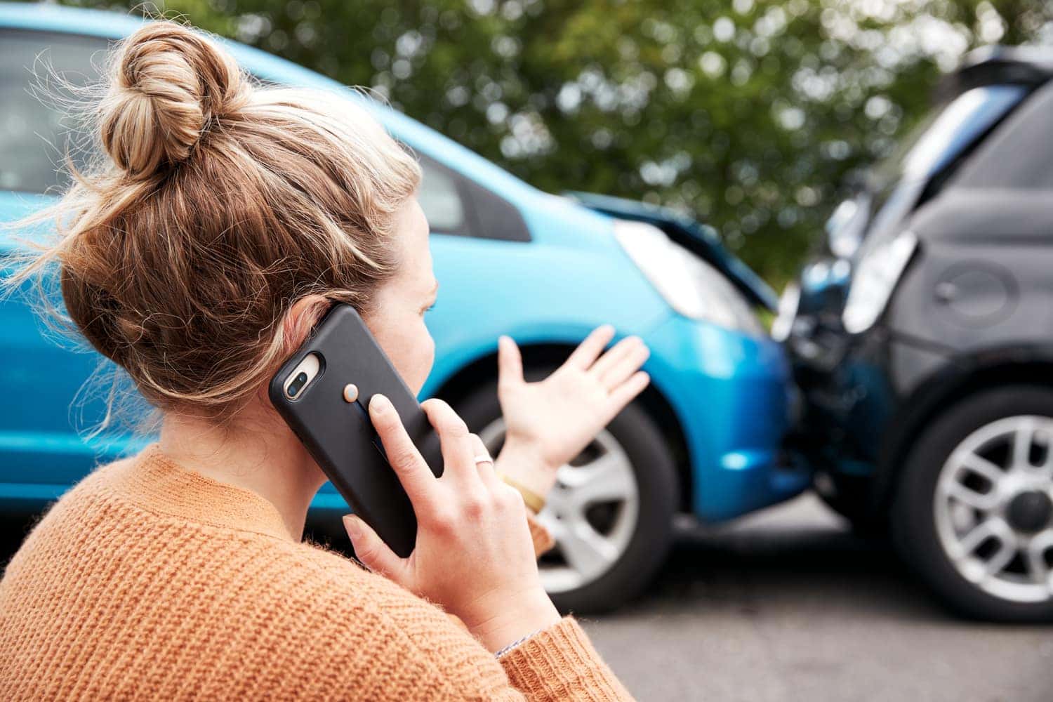 Woman on phone with Chevrolet Service Center explaining the rear-end collision accident her car was in