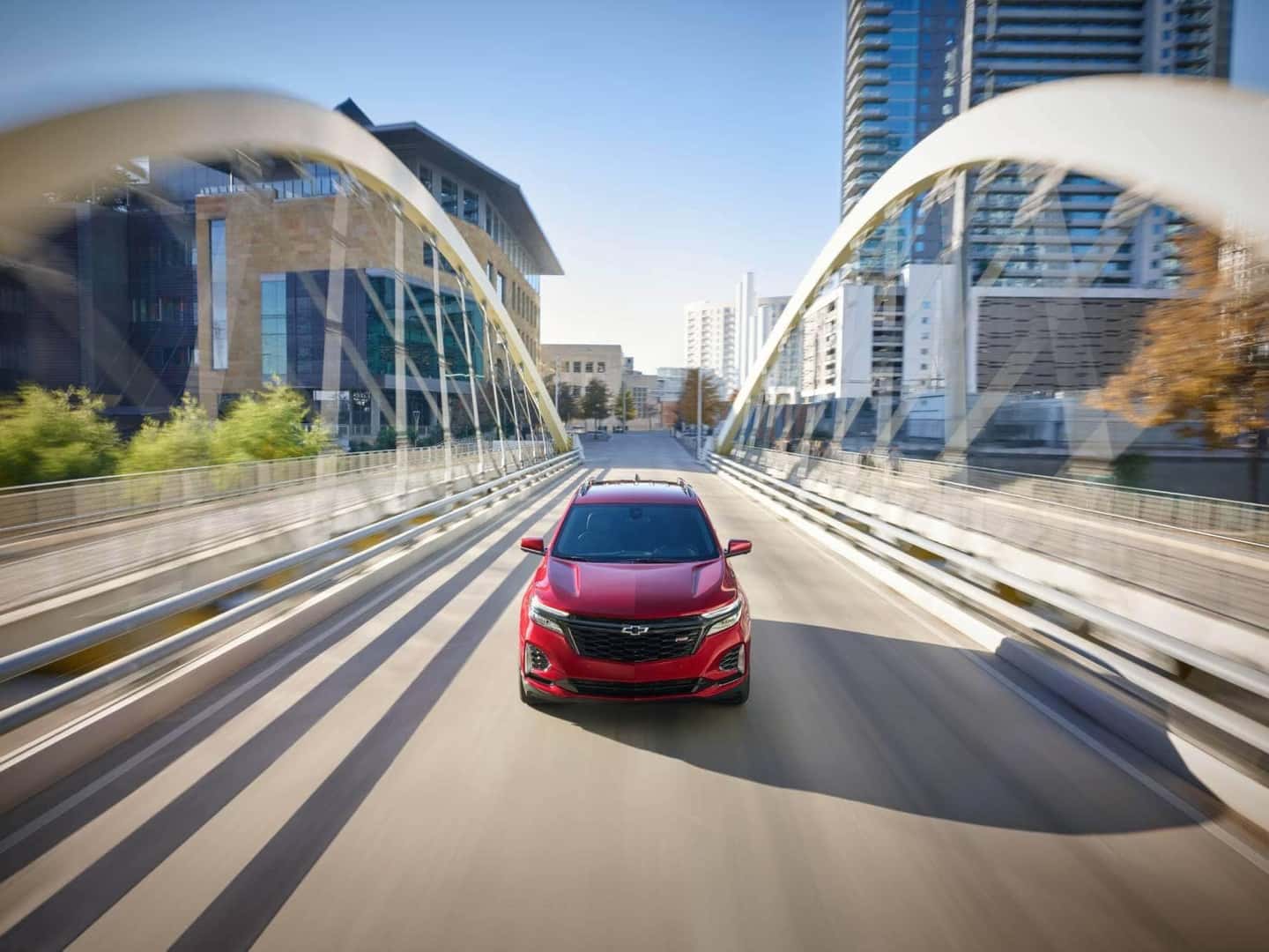 Front overhead view of Chevrolet Equinox SUV driving on bridge with motion blur