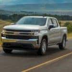 A silver 2020 Chevy Silverado LT is driving on a highway. Check out these great chevy trucks at a dealer in Indianapolis, IN.