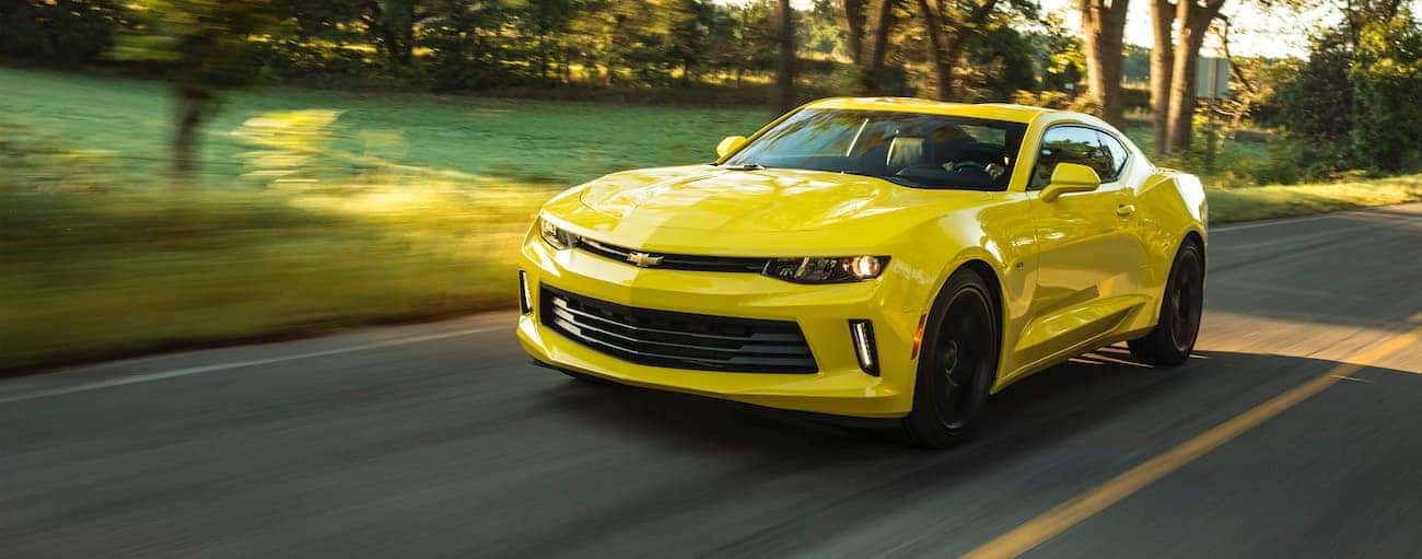 A yellow 2018 used Chevrolet Camaro is driving on a sunny road outside of Indianapolis, IN.