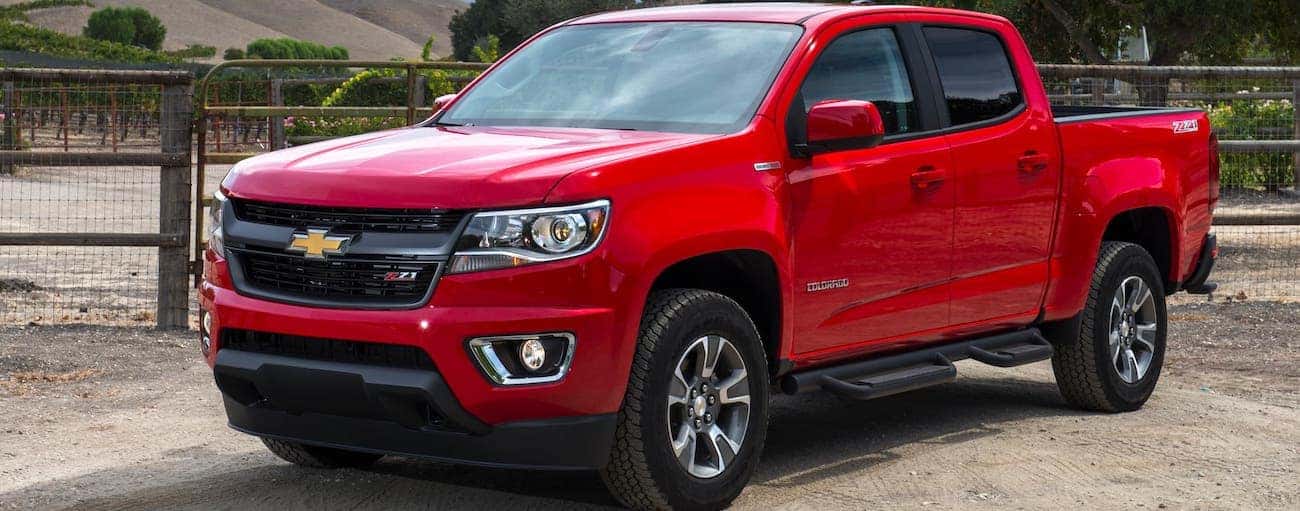 A red 2018 used Chevrolet Colorado Z71 is parked in front of a farm.