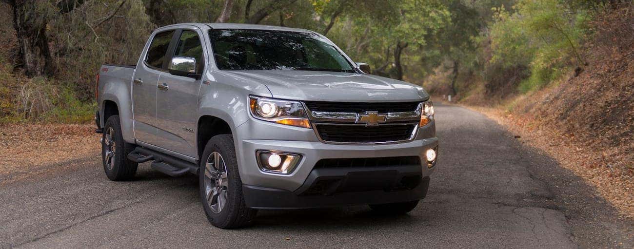 A silver 2019 used Chevrolet Colorado is parked on a road in the woods outside Indianapolis, IN.