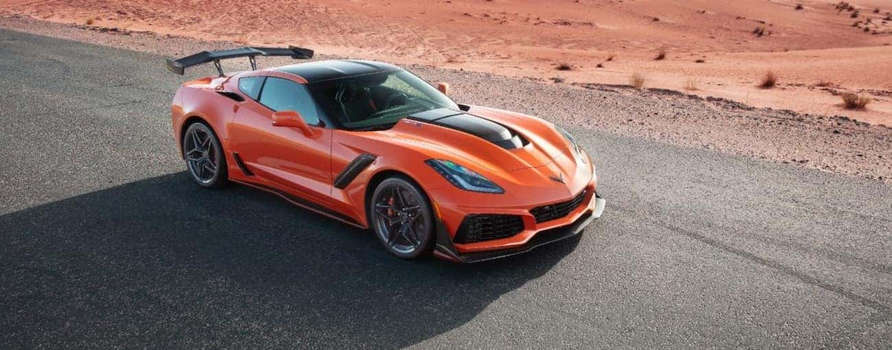 An orange 2019 used Chevrolet Corvette is parked on a desert road.