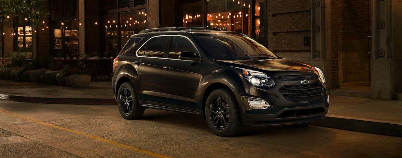 A black 2017 used Chevrolet Equinox Midnight Edition is parked on an Indianapolis, IN, street at night.