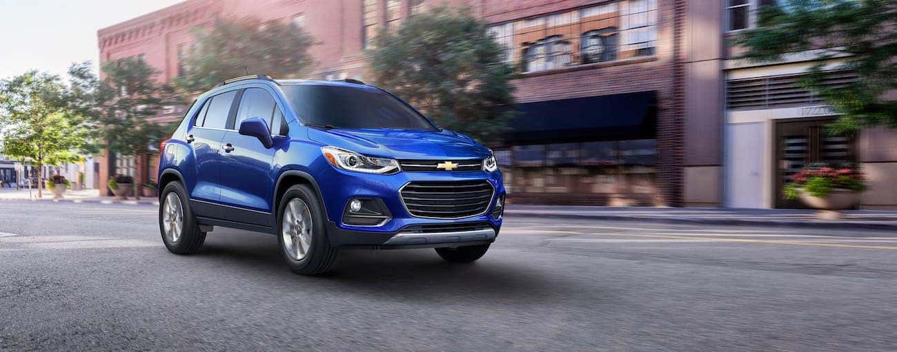A blue 2017 used Chevrolet Trax is driving on an Indianapolis, IN, street.