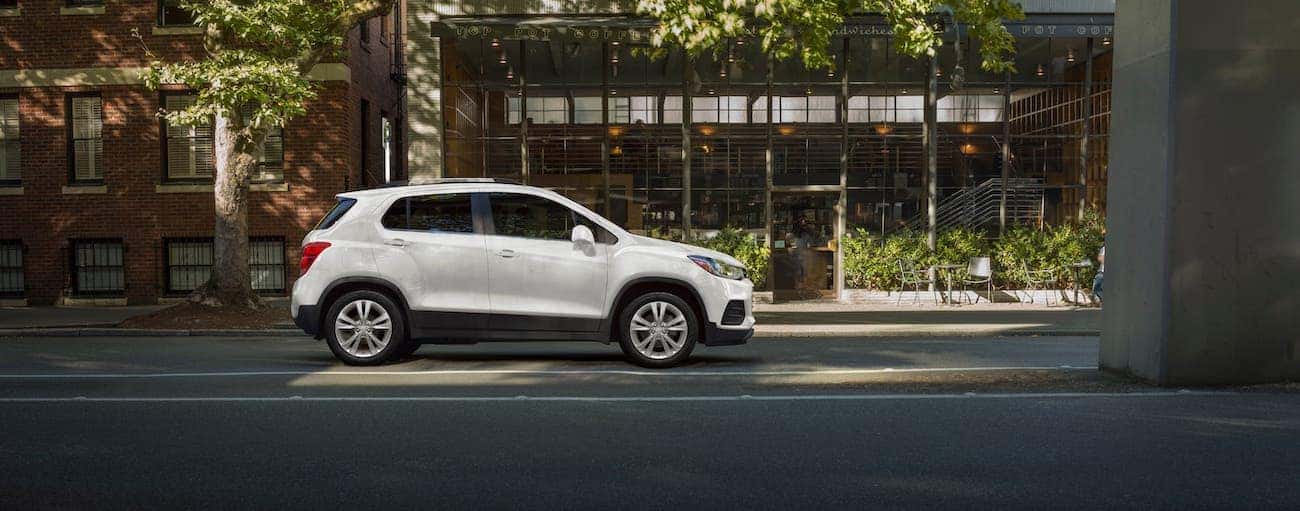 A white 2019 used Chevrolet Trax is parked in front of a cafe.