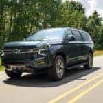 A new Chevy SUV, a gray 2021 Chevy Suburban Z71, is driving on a highway near Indianapolis, IN.