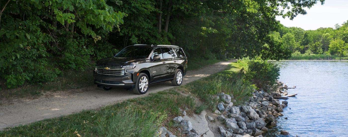 A brown 2021 Chevy Tahoe High Country is driving around a pond near Indianapolis, IN.