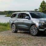 One of the newer Chevy SUVs, a gray 2021 Chevy Suburban Z71, is parked in front of a river near Indianapolis, IN.