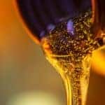 A close up is showing fresh oil pouring out of a container.