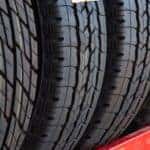 Multiple tires are shown on a metal tire rack at a tire shop near you.