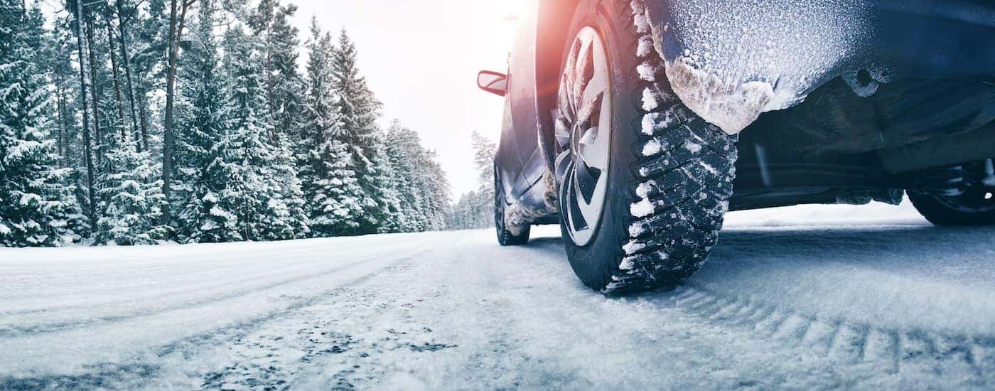 A car is driving on a snowy road after leaving a shop in Indianapolis for winter tires.