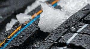 A close up shows snow in the treads of a brand new tire.