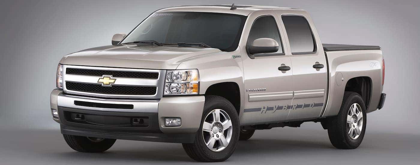 A silver 2009 Chevy Silverado Hybrid is shown on a grey background.