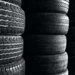 A close up shows multiple stacks of tires.