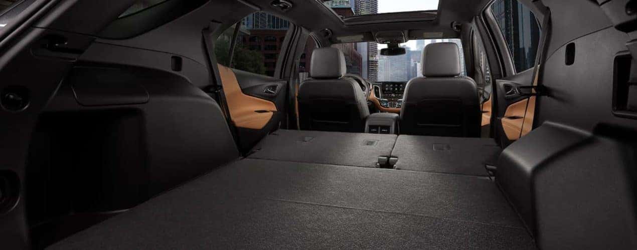 The cargo area of a 2021 Chevy Equinox is shwon with the rear seats folded down.