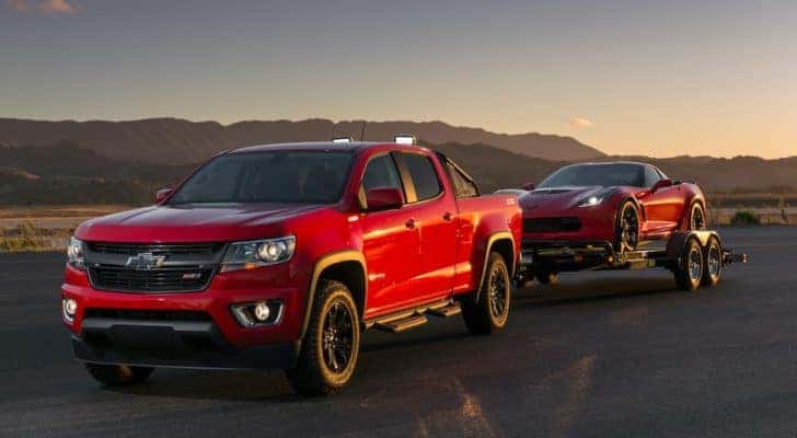 A red 2016 Chevy Colorado Z71 is shown towing a 2016 red Chevy Corvette home after visiting a pre-owned car dealer in Indianapolis.