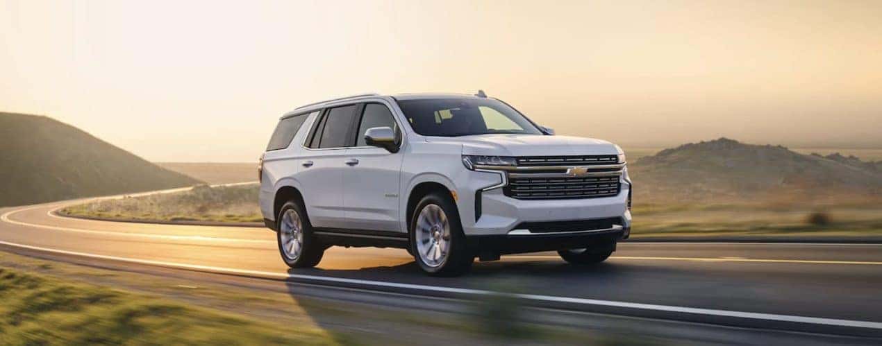 A white 2022 Chevy Tahoe is shown driving on an open road.