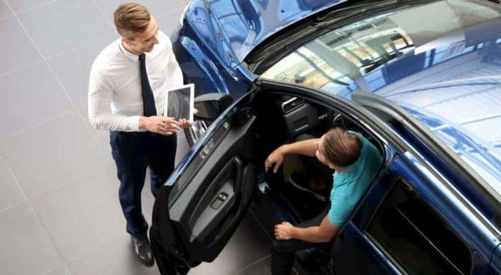 A salesman is shown speaking to a customer at a certified pre-owned Chevy dealer in Indianapolis.