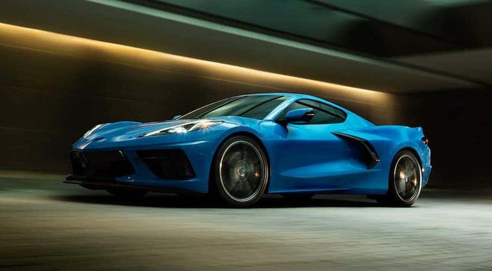 A blue 2020 Chevy Corvette is shown from the side driving through a tunnel.