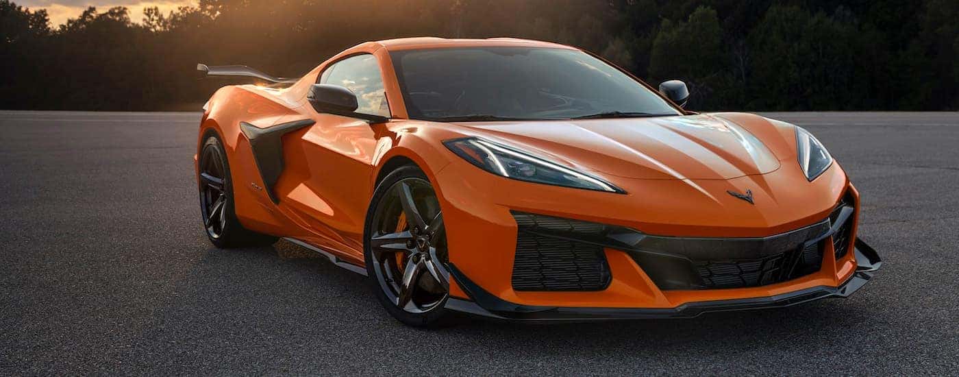 An orange 2023 Chevy Corvette Z06 is shown parked on pavement after visiting an Avon Chevrolet dealer. 