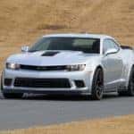 A silver 2015 Chevy Camaro Z28 is shown from the front driving on a track.