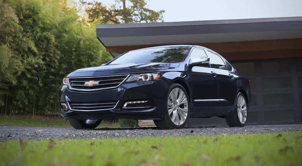 A black 2018 Chevy Impala is shown parked in front of a house.