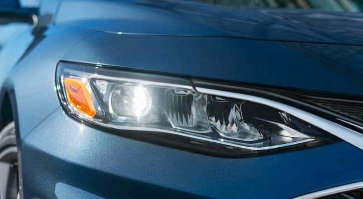 A close up shows the passenger side headlight on a blue 2021 Chevy Malibu.