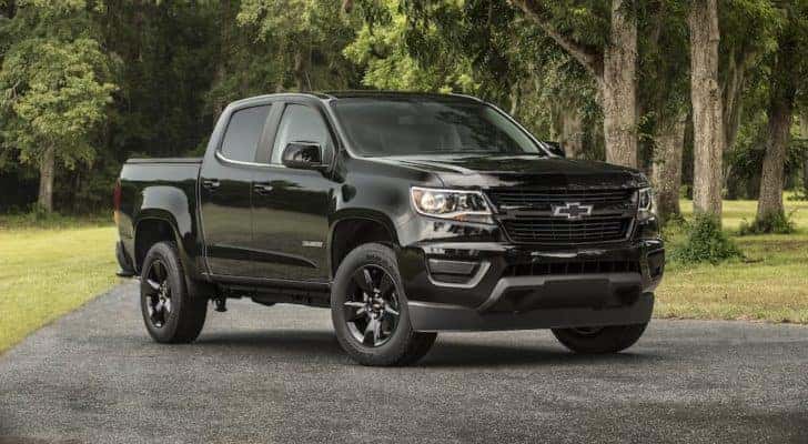 A black 2016 Chevy Colorado Midnight Edition is shown on pavement after leaving a used Chevrolet dealership.