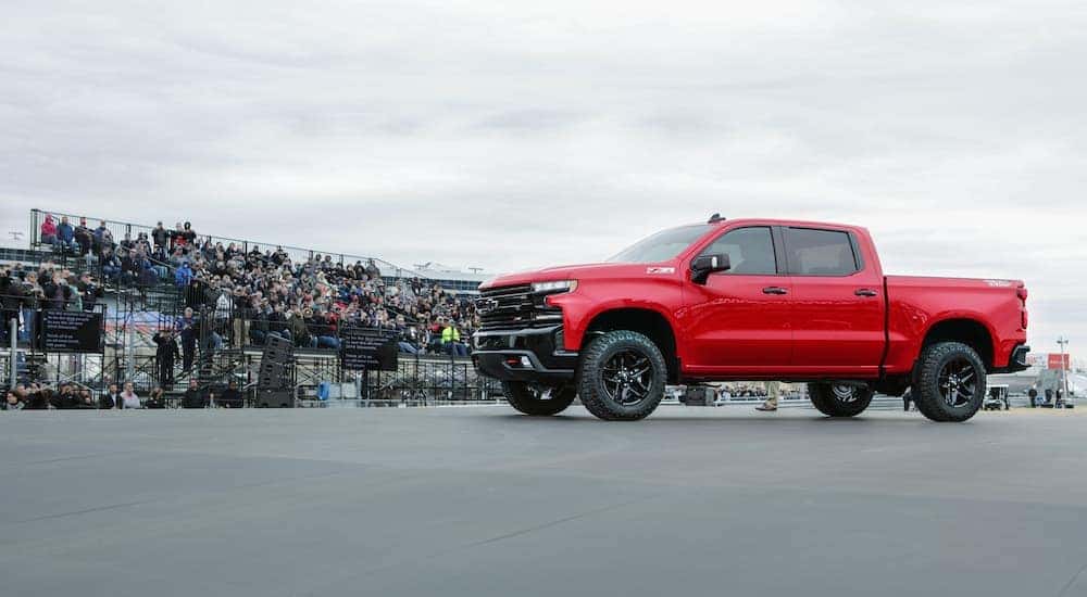 A red 2019 Chevy Silverado Z71 is shown near a crowd after visiting a used Chevrolet dealership.