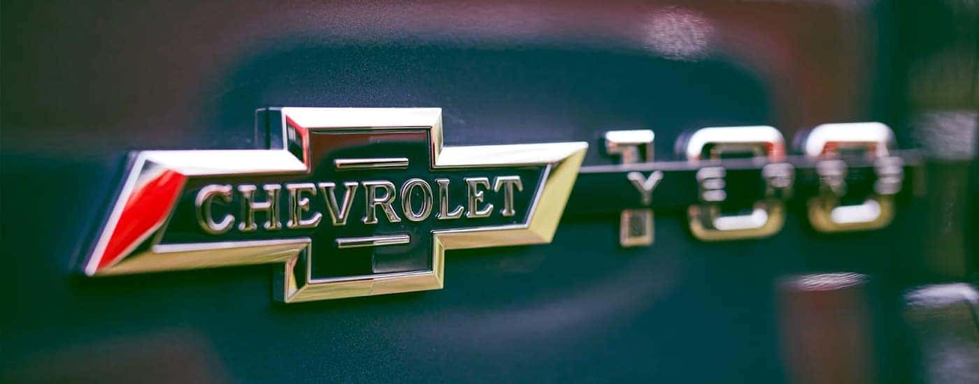 A close up shows the Chevy 100 Years logo on a blue truck.