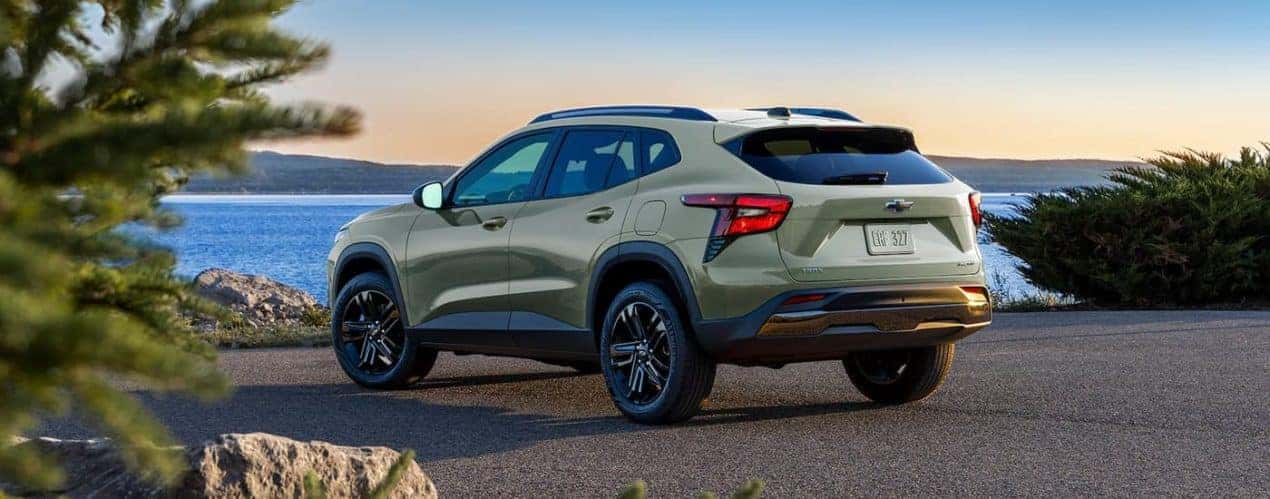 A green 2024 Chevy Trax Activ is shown from the rear overlooking a lake.