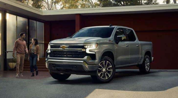 Front view of a silver 2023 Chevy Silverado 1500 Z71 parked in front of a house.