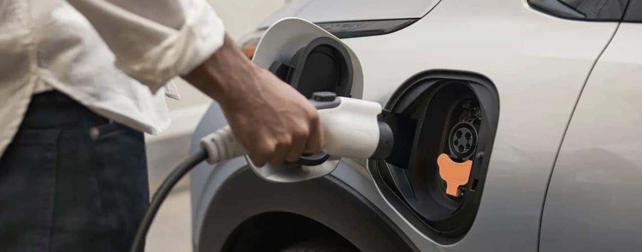 A person is shown plugging in a 2023 Chevy Bolt EUV.