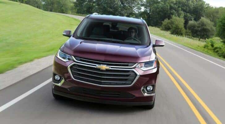 A purple 2018 Chevy Traverse for sale near Greenfield, IN is shown driving on an open road.