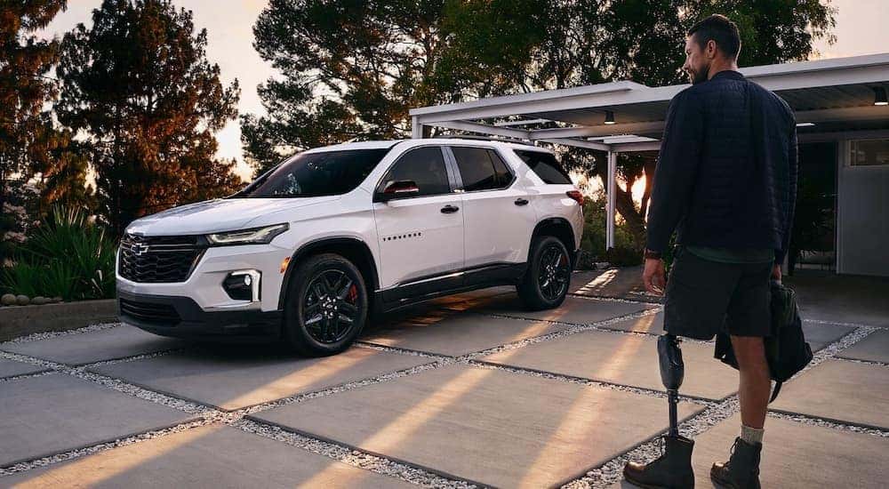 A white 2023 Chevy Traverse is shown from the front at an angle while parked in a driveway.
