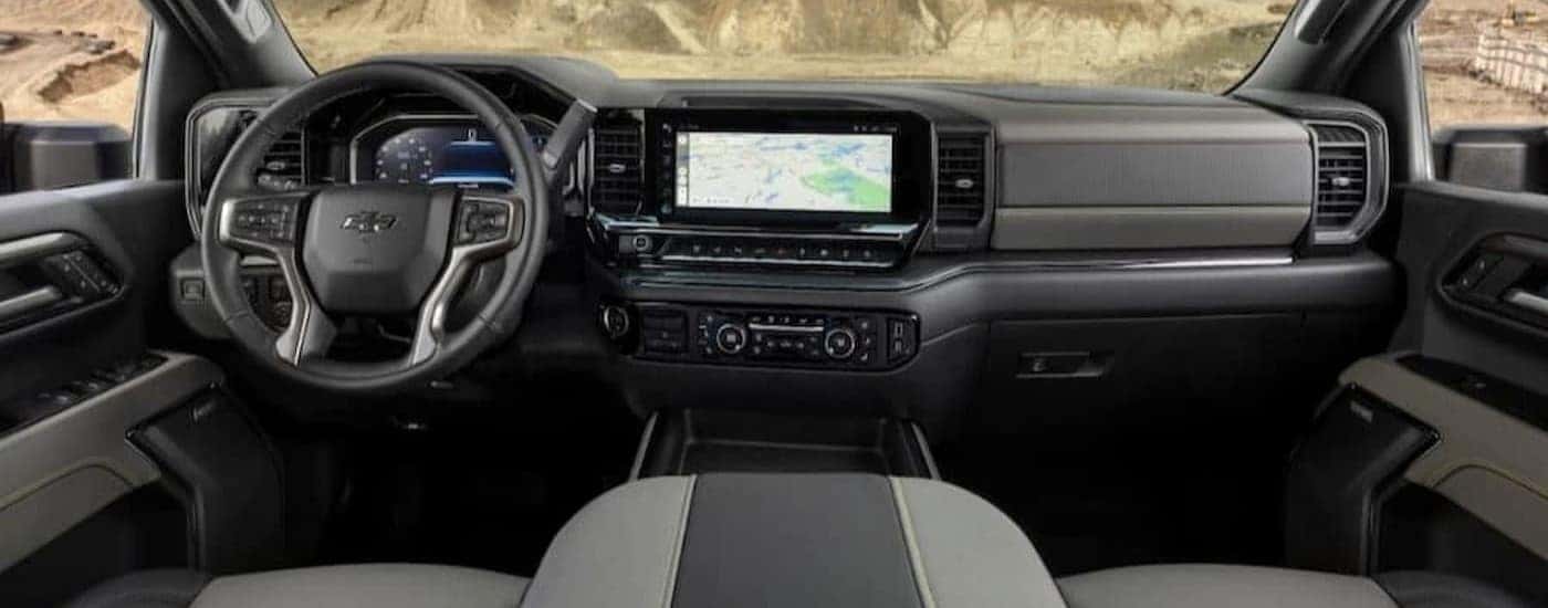 The black and gray interior and dash of a 2024 Chevy Silverado 1500 is shown.