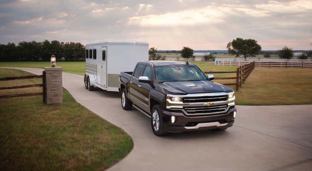 A black 2017 Chevy Silverado 1500 is shown towing a trailer after visiting a used truck dealer in Indianapolis.