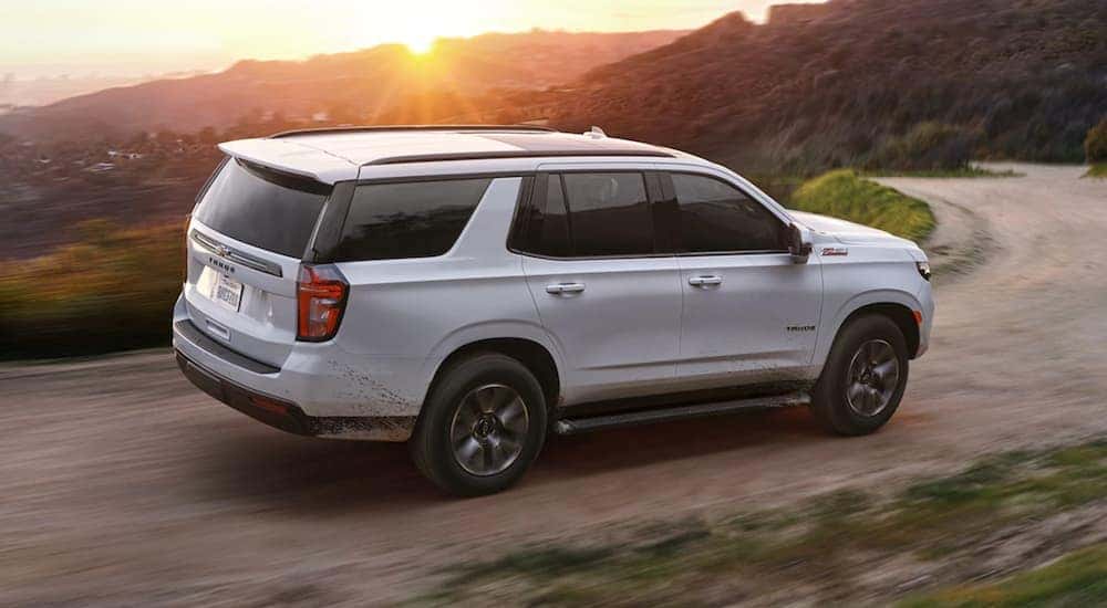A white 2021 Chevy Tahoe Z71 is shown from the side on a dirt trail.