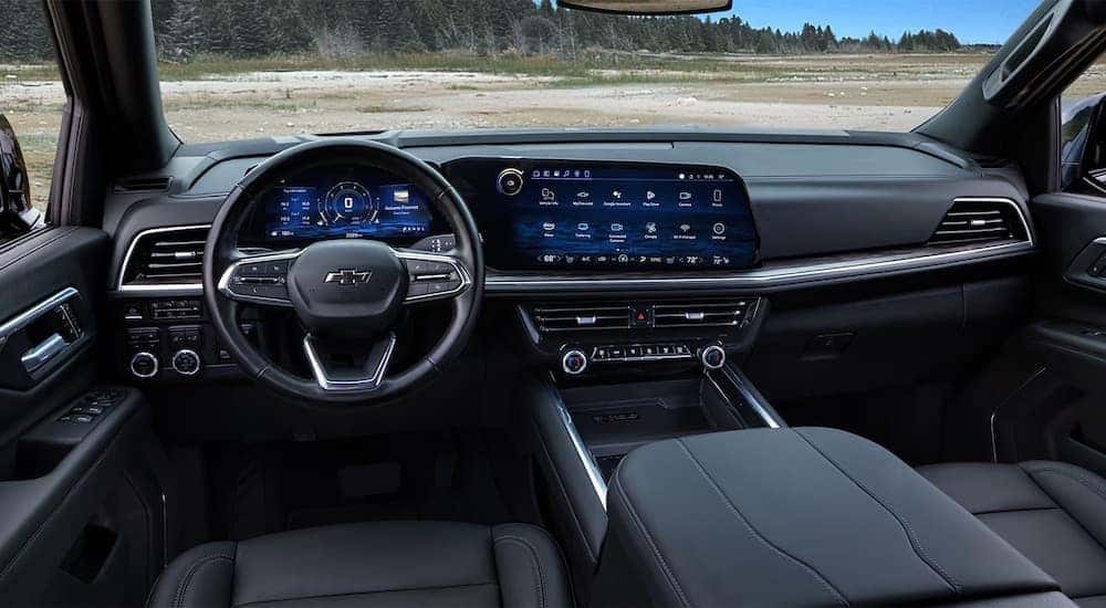 The black interior of a 2025 Chevy Suburban is shown from the front seat.