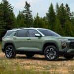 A sage green 2025 Chevy Equinox ACTIV parked in an open meadow.