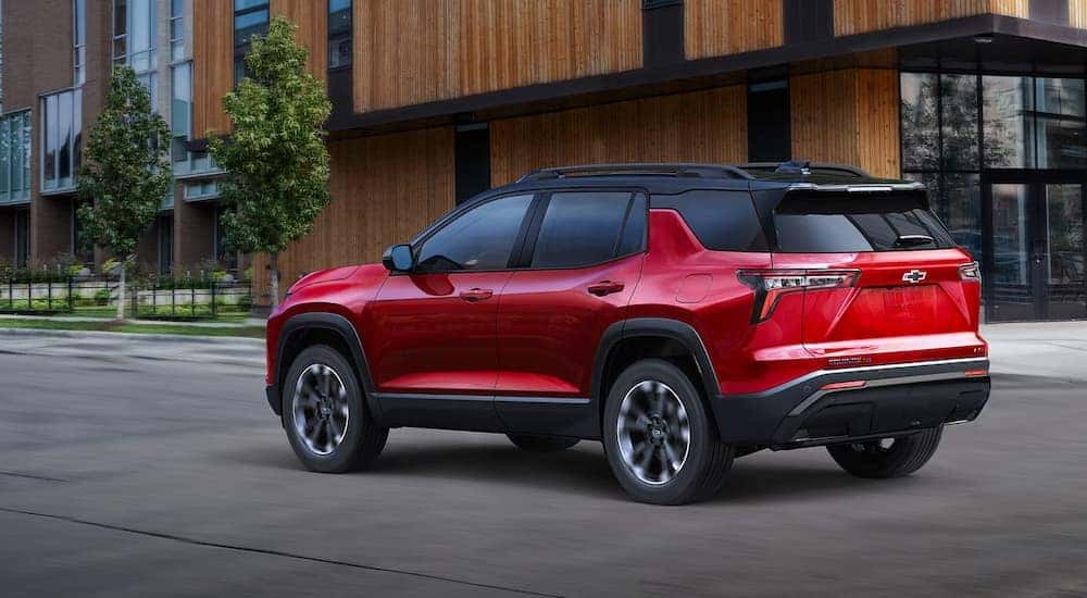 A red 2025 Chevy Equinox RS driving to a Chevy dealer near Beech Grove.