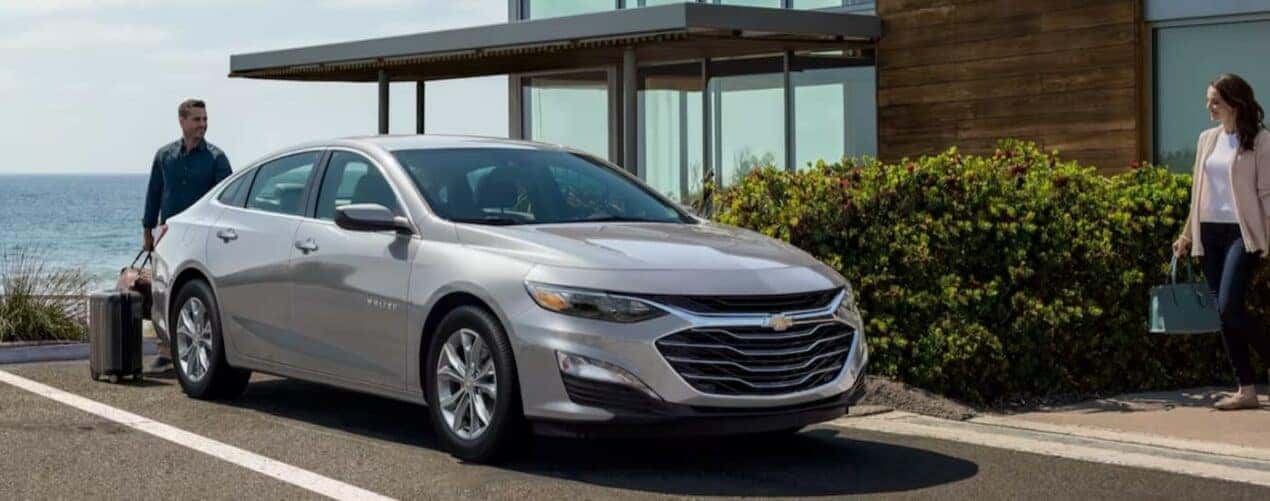 A silver 2024 Chevy Malibu is shown parked in a parking spot.