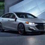 A silver 2024 Chevy Malibu Redline Edition parked at night.
