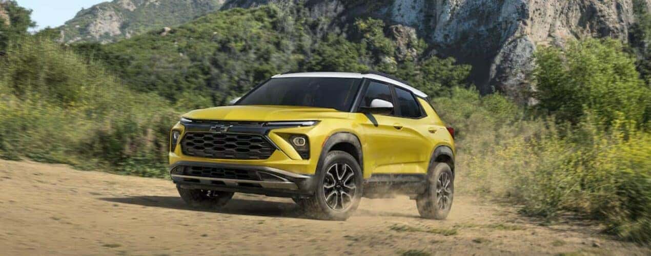 A yellow 2024 Chevy Trailblazer ACTIV is shown driving off-road.