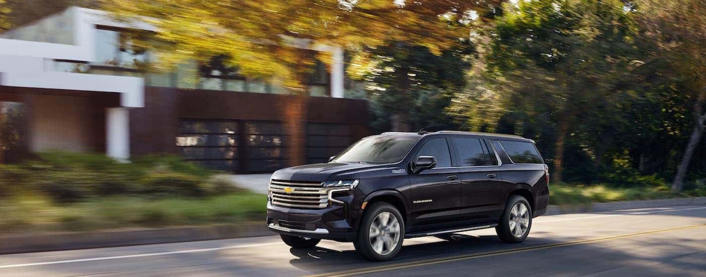 A grey 2022 Chevy Suburban High Country is shown from the side.