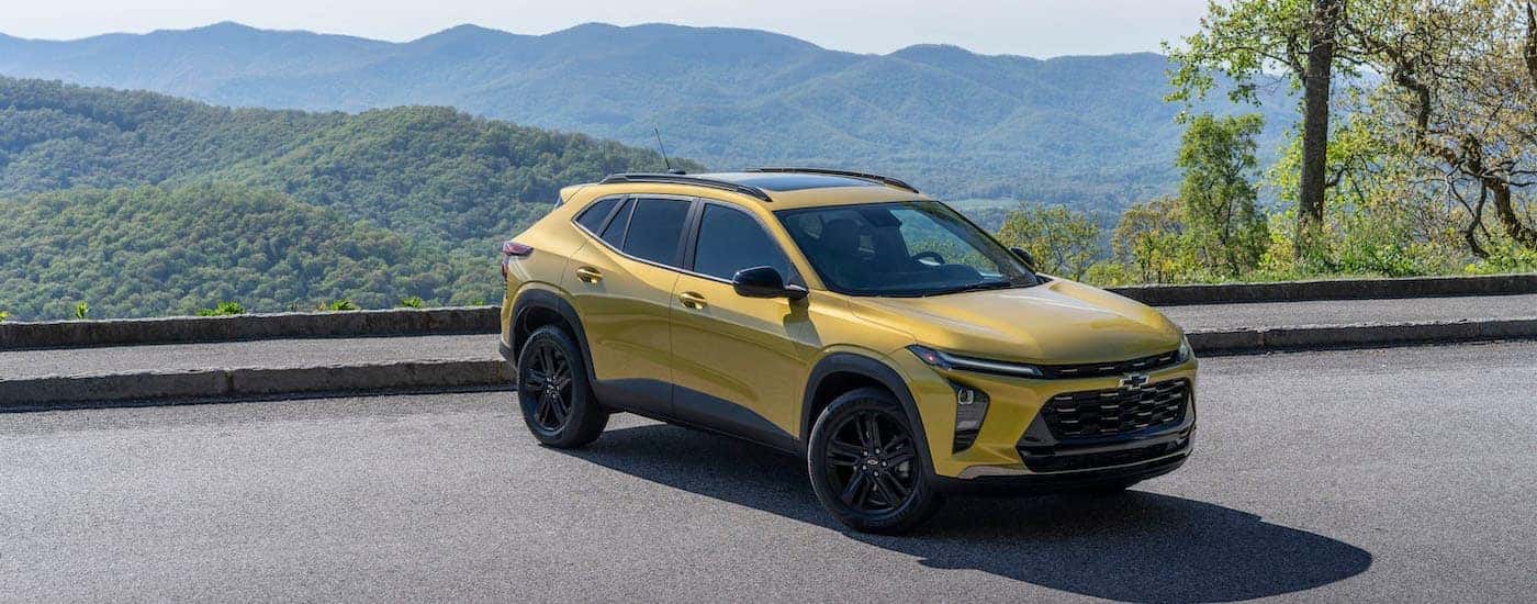 A yellow 2024 Chevy Trax ACTIV is shown from the front at an angle after leaving a dealer that has SUVs for sale.