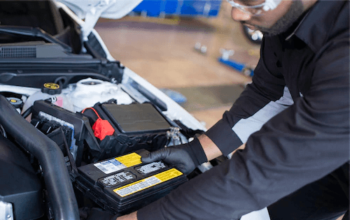 Service technician replacing car battery